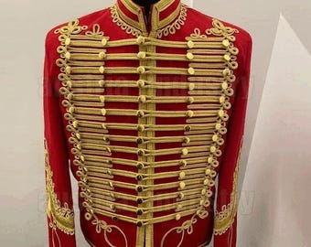 May include: A red military-style jacket with gold-colored trim and buttons. The jacket features a high collar and intricate gold embroidery along the front, sleeves, and collar. The design is symmetrical, with rows of gold trim and buttons.