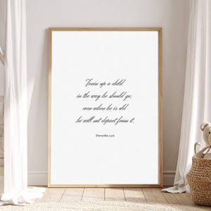 May include: A framed print with the text "Train up a child in the way he should go; even when he is old he will not depart from it. Proverbs 22:6" in a script font. The frame is light brown.