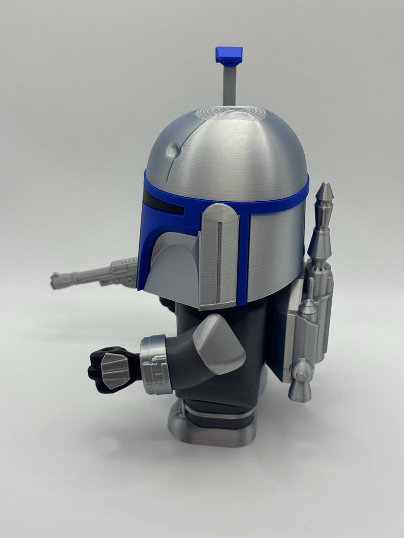 Peut inclure: Figurine argent&eacute;e et bleue d'un personnage avec un casque, un jetpack et un blaster. La figurine a un casque bleu et argent&eacute; avec une antenne grise. La figurine porte une combinaison noire et argent&eacute;e.