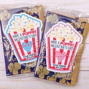 May include: Two Valentine's Day gift bags with popcorn-themed cards. The cards have red and white stripes and say "Have a Poppin' Valentine's Day!" with a heart and "Your Friend, Mylah".