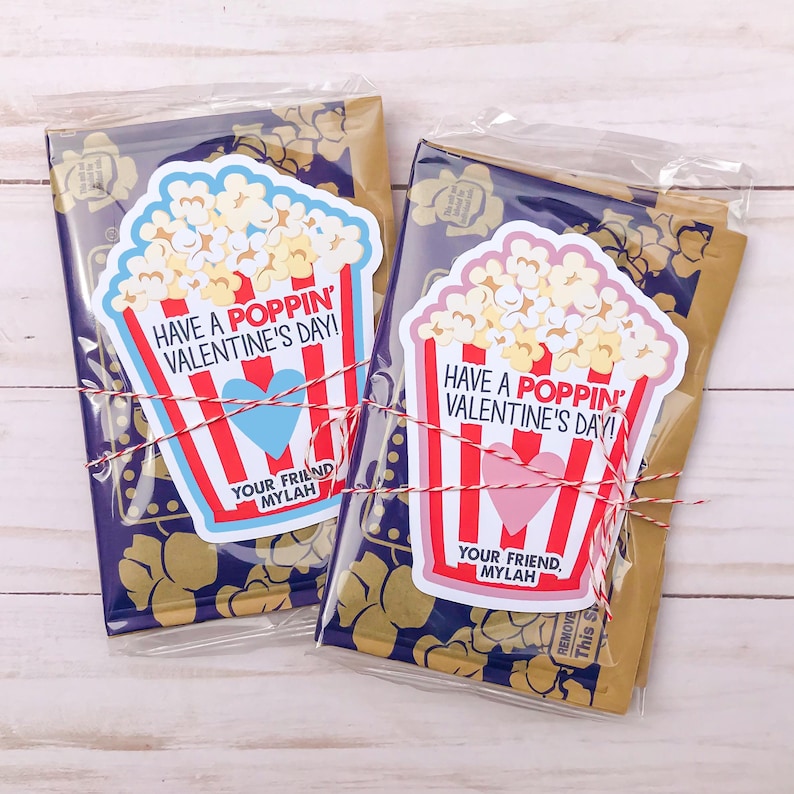 May include: Two Valentine's Day gift bags with popcorn-themed cards. The cards have red and white stripes and say "Have a Poppin' Valentine's Day!" with a heart and "Your Friend, Mylah".