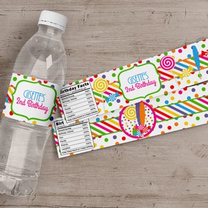 Peut inclure: &Eacute;tiquette de bouteille d'eau sur le th&egrave;me des bonbons color&eacute;s. L'&eacute;tiquette indique "Gisette's 2nd Birthday" et pr&eacute;sente des sucettes, des cannes &agrave; sucre et des p&eacute;pites.