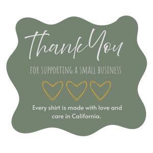 May include: A green, cloud-shaped graphic with the words "Thank You" in white script. Below, it reads "FOR SUPPORTING A SMALL BUSINESS" and features three gold heart outlines. The text "Every shirt is made with love and care in California" is at the bottom.