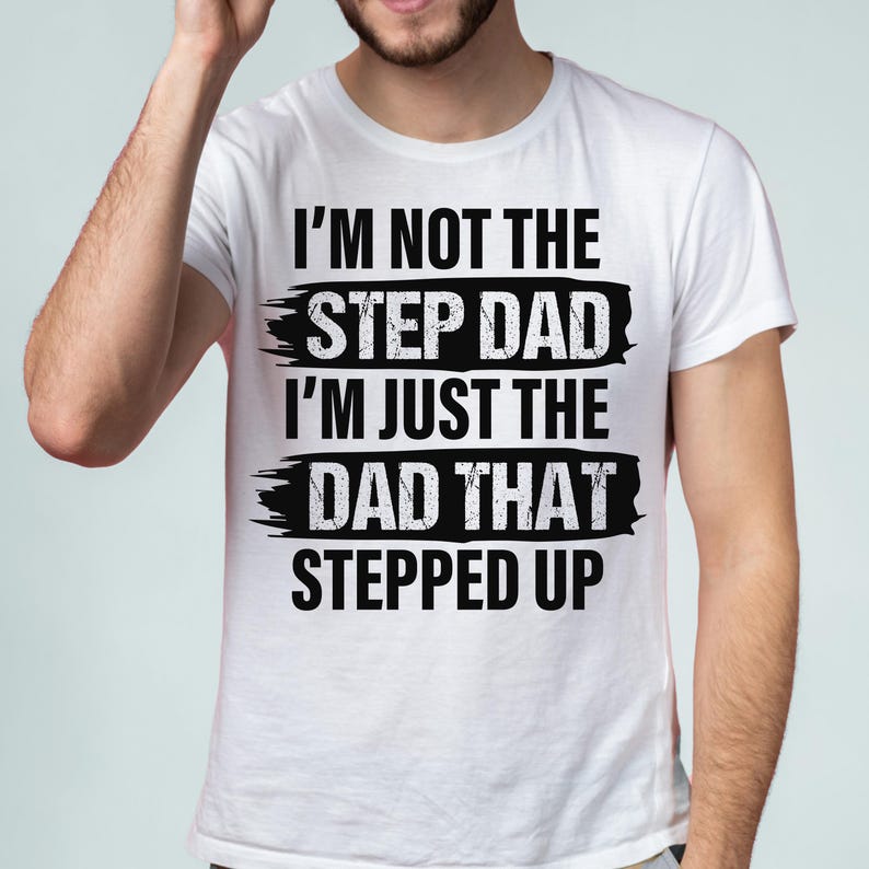 Puede incluir: Camiseta blanca con el texto negro: "I'M NOT THE STEP DAD I'M JUST THE DAD THAT STEPPED UP". El texto est&aacute; en negrita, estilizado, con un efecto de pincelada desgastada.
