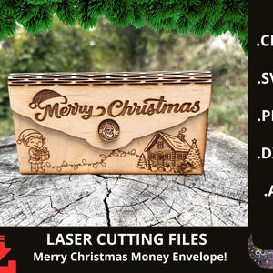 May include: A laser-cut wooden money envelope featuring a Christmas theme. The design includes the words "Merry Christmas", an elf, a house, and fairy lights. The envelope is made of light-coloured wood.