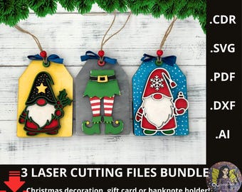 May include: Three wooden Christmas decorations with gnome and elf designs. Each tag-shaped ornament has a different colour scheme: yellow, grey, and blue. The ornaments are decorated with red, green, and white details. The text reads "3 LASER CUTTING FILES BUNDLE".