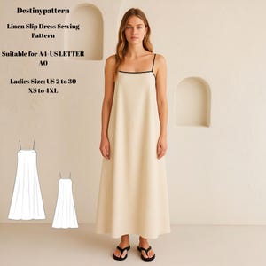 May include: A cream-coloured linen slip dress with black trim is worn by a woman. The dress features thin straps and a flowing design. The image includes a sewing pattern with the text "Destinypattern" and "Linen Slip Dress Sewing Pattern". The dress is available in sizes US 2 to 30.
