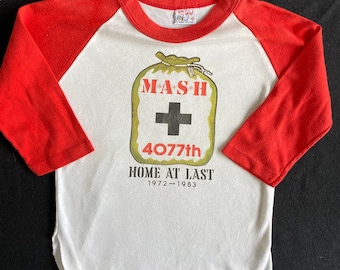 Vintage 80er Jahre Kinder MASH 4077th Home at Last 1972-1983 Ringer Raglan Baseball Jersey T Shirt Weich und Getragen Sammler Classic Größe Jugend M