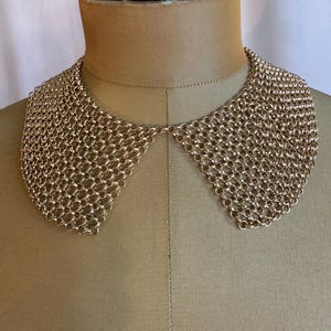 Collar de malla metálica dorada estilo vintage de los años 60 con cierre de pedrería. Estilo clásico y versátil.