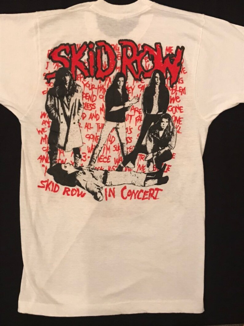 Op de afbeelding: Wit T-shirt met een afbeelding van de band Skid Row in concert. Het ontwerp bevat de naam van de band in het rood, bandleden en songteksten. Het shirt heeft een klassieke ronde hals en korte mouwen.