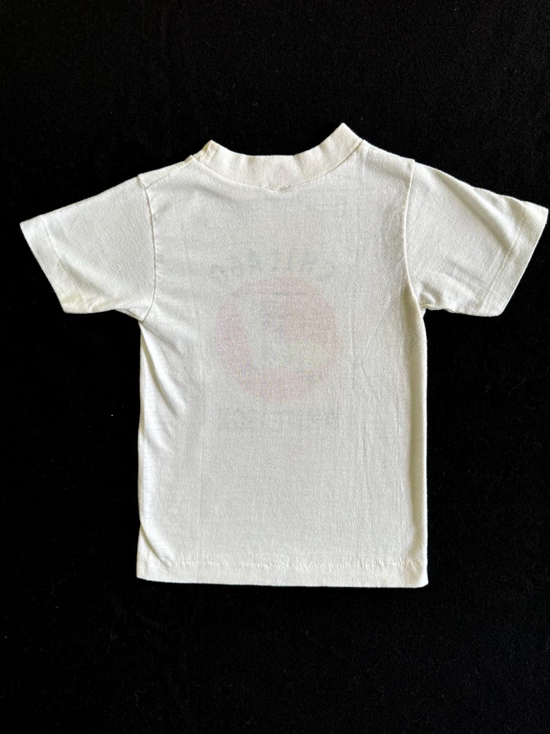 K&ouml;nnte beinhalten: Wei&szlig;es T-Shirt mit kurzen &Auml;rmeln und einem verblassten Aufdruck auf der Vorderseite.