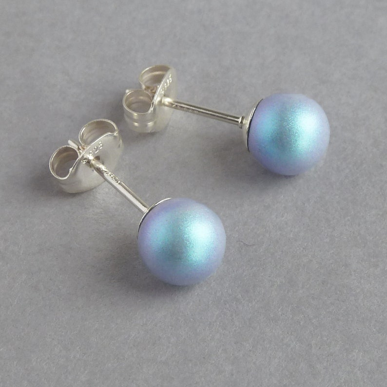 May include: A pair of silver stud earrings with iridescent blue round beads.