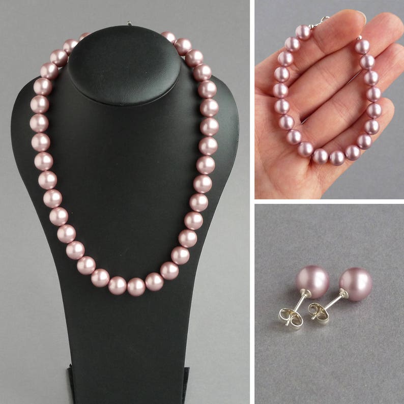 May include: A set of blush-colored pearl jewelry, including a necklace on a black display stand, a bracelet, and a pair of stud earrings. The pearls have a soft, lustrous finish. The earrings have silver posts.