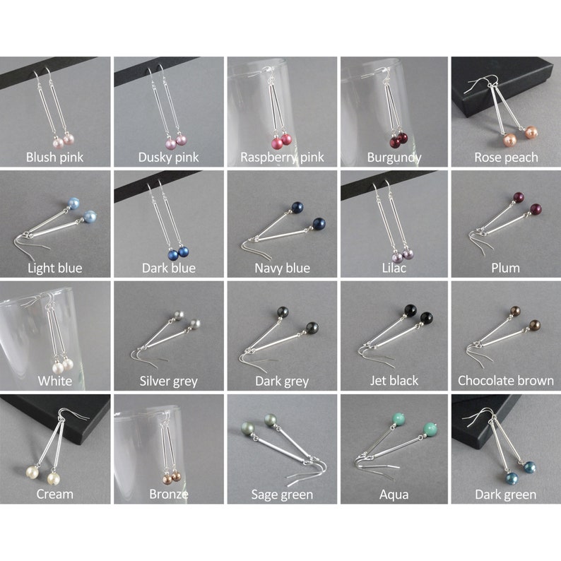 May include: A set of 20 pairs of dangle earrings with silver bars and different colored pearl beads. The earrings are displayed on a gray background.