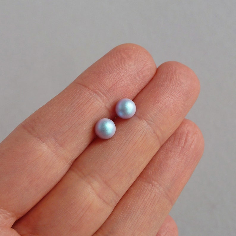 May include: A pair of iridescent blue pearl stud earrings.