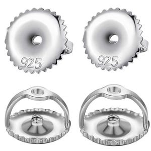 Puede incluir: Primer plano de cuatro cierres de pendientes plateados. Dos son redondos con un borde festoneado y el número "925" estampado. Los otros dos tienen una barra curva unida a una base redonda con un borde festoneado.