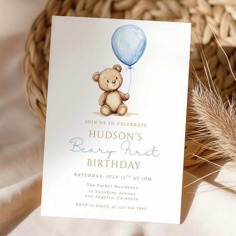May include: A birthday invitation featuring a watercolor illustration of a teddy bear holding a blue balloon. The invitation text reads "Hudson's Beary First Birthday" with event details. The design is on a white background.