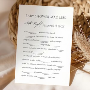 Peut inclure: Une carte blanche de jeu Baby Shower Mad Libs avec du texte noir. Le titre de la carte est "Baby Shower Mad Libs Late Night Feeding Frenzy". La carte comporte des sections à remplir pour un jeu amusant.