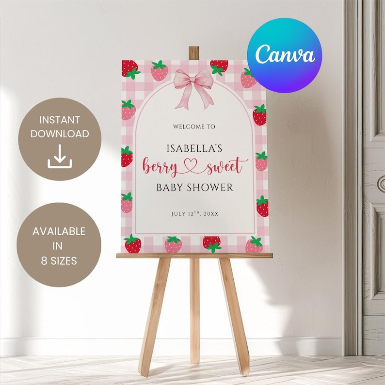 May include: A pink and white baby shower sign with a strawberry theme. The sign reads "Welcome to Isabella's berry sweet baby shower" with a pink bow and strawberry illustrations. The sign is displayed on a wooden easel.