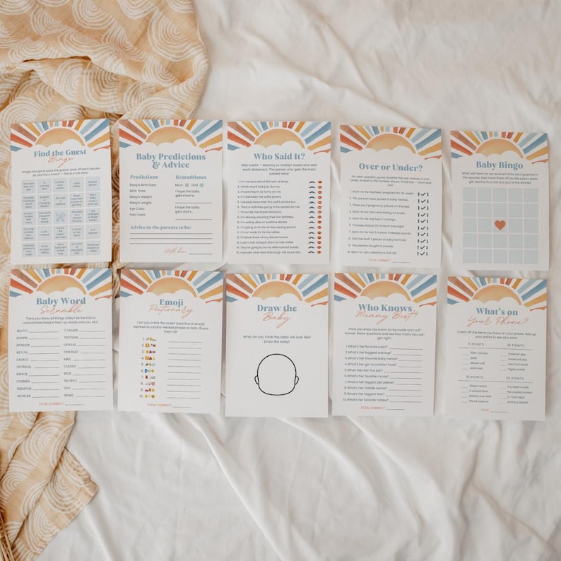 Puede incluir: Un conjunto de tarjetas de juegos para baby shower con un dise&ntilde;o de sol y arco&iacute;ris. Las tarjetas incluyen juegos como "Encuentra al invitado", "Baby Bingo" y "Dibuja al beb&eacute;". La paleta de colores incluye naranja, azul y amarillo.