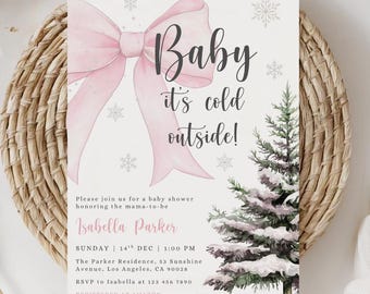 Puede incluir: Invitación a baby shower con un lazo rosa, copos de nieve y un árbol de pino nevado. El texto dice "Baby it's cold outside!" e incluye detalles para el baby shower de Isabella Parker.