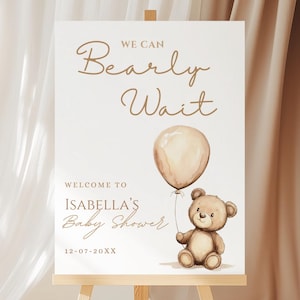 Könnte beinhalten: Willkommensschild für eine Babyparty auf einer Staffelei. Auf dem Schild steht "We Can Bearly Wait" und "Welcome to Isabella's Baby Shower". Ein Teddybär hält einen Ballon. Das Datum 12-07-20XX wird ebenfalls angezeigt.
