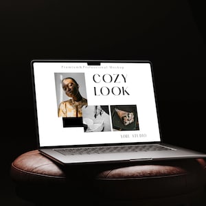 May include: A silver laptop showing a "COZY LOOK" mockup with images and text. The laptop is placed on a brown leather ottoman against a dark backdrop. The screen displays a woman, a decorative object, and a bouquet.