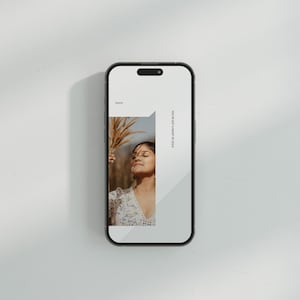 Op de afbeelding: Een smartphone mockup met een witte achtergrond en een vrouw met bruin haar die een witte bloemenjurk draagt en een gedroogde bloem vasthoudt. De tekst op het scherm luidt "You've got a heart of gold".