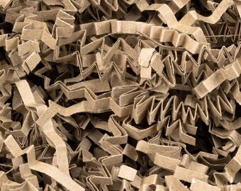 May include: Close-up of shredded brown corrugated cardboard packaging material. The material is cut into zig-zag shapes, creating a textured and layered appearance. This eco-friendly packaging is ideal for cushioning and protecting items during shipping.