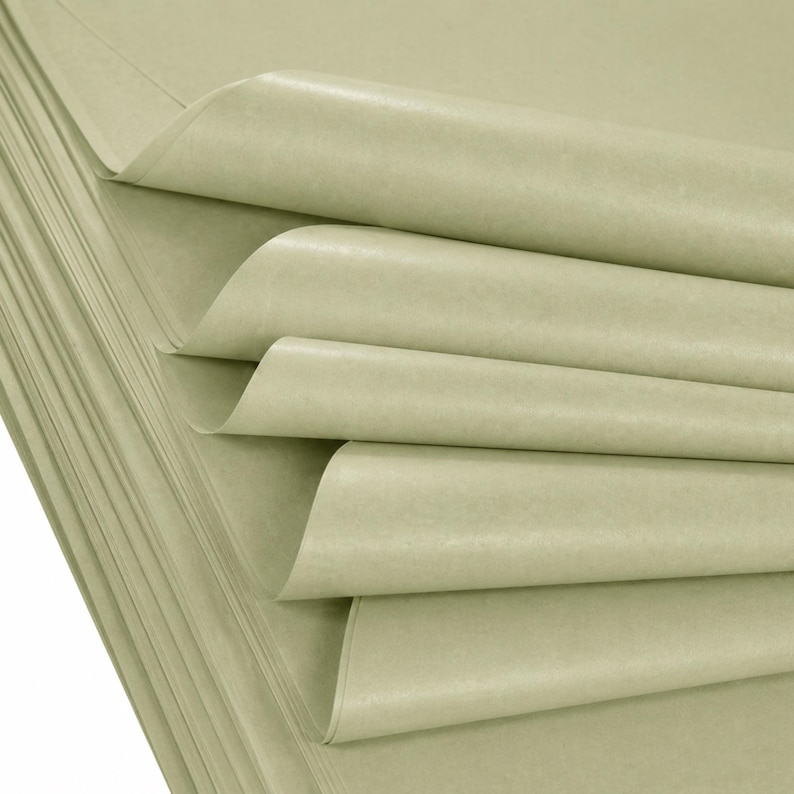 May include: A stack of light green tissue paper sheets, with several sheets partially unfolded to reveal their texture. The paper has a slightly wrinkled appearance and a matte finish. The sheets are neatly stacked.