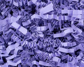 May include: Close-up of shredded lavender paper, ideal for gift packaging or crafting. The paper is cut into thin, wavy strips, creating a textured and voluminous appearance. The color is a soft, muted purple, providing a delicate and elegant aesthetic.