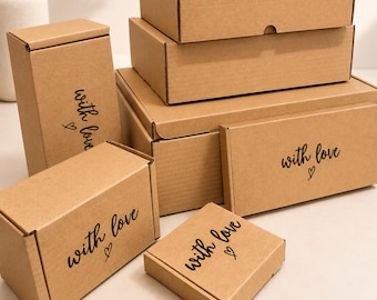 May include: A collection of brown cardboard shipping boxes in various rectangular and square sizes. Each box features the black printed text "with love" accompanied by a small hand-drawn heart symbol on the front or top surface.