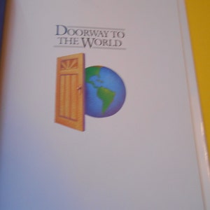 Puede incluir: Portada de libro con el título "Doorway to the World". La portada presenta una puerta de madera que se abre a un globo terráqueo. El globo es azul y verde, representando la Tierra. El fondo es blanco.