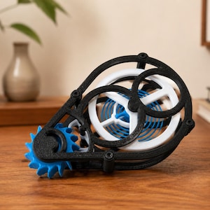May include: A mechanical gear assembly featuring a black frame, a white circular gear, and a bright blue spiral spring mechanism. The components are held together by small black screws, creating a complex, exposed structure with visible teeth.