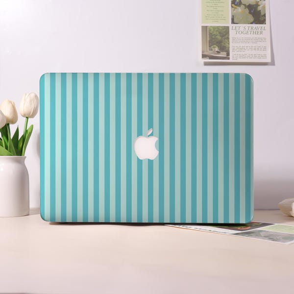 Könnte beinhalten: Eine Laptop-Hülle mit teal- und hellblauen Streifen und einem weißen Apple-Logo. Die Hülle befindet sich auf einem weißen Schreibtisch mit einer Vase mit weißen Tulpen links. Ein kleiner gerahmter Druck befindet sich im Hintergrund.