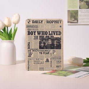May include: A rectangular sign with a newspaper design featuring the headline "BOY WHO LIVED." The sign has a vintage aesthetic with text and a black and white photo of a group of people. The text includes "DAILY PROPHET" and "IS NOTHING TO FEAR!"