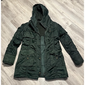 May include: Dark green hooded winter coat with a faux fur-lined hood. The coat features multiple pockets, a button and zipper closure, and gathered fabric details on the sleeves. The coat is made of a shiny, water-resistant material.