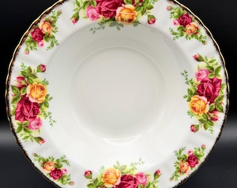 May include: White ceramic bowl with a scalloped edge and a gold rim. The bowl is decorated with clusters of red, pink, and yellow roses with green leaves. The bowl is likely for serving food.