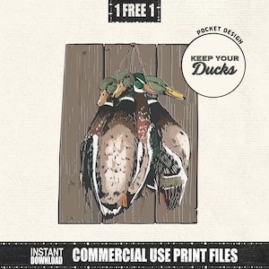 以下が含まれることがあります： 木板に吊るされた3羽のアヒルのイラスト。アヒルは茶色、白、緑色の羽を持っています。「KEEP YOUR Ducks」というテキストが入った円形のデザインが右側にあります。画像には「1 FREE 1」と「COMMERCIAL USE PRINT FILES」というテキストも含まれています。