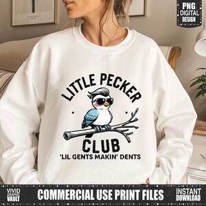 Puede incluir: Sudadera blanca con un p&aacute;jaro de dibujos animados con gafas de sol, posado en una rama. El texto encima del p&aacute;jaro dice "LITTLE PECKER" y debajo, "CLUB" y "'LIL GENTS MAKIN' DENTS". El dise&ntilde;o es una impresi&oacute;n digital.