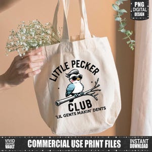 Puede incluir: Una bolsa de mano de color crema con un p&aacute;jaro de dibujos animados con gafas de sol y el texto "LITTLE PECKER CLUB". El p&aacute;jaro est&aacute; posado en una rama. La bolsa tambi&eacute;n tiene el texto "'LIL GENTS MAKIN' DENTS".