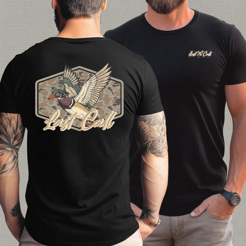 May include: Black t-shirts with a duck graphic. One shirt features a large design on the back with a duck in flight, camouflage background, and the text "Last Call." The other shirt has a smaller logo on the chest.