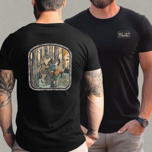 Op de afbeelding: Zwarte T-shirts met een thema-afbeelding van de natuur. E&eacute;n shirt heeft een rechthoekige patch met de tekst "KEEP YOUR Ducks". Het andere shirt heeft een vierkante patch op de rug met een eendenillustratie in een bosrijke omgeving.