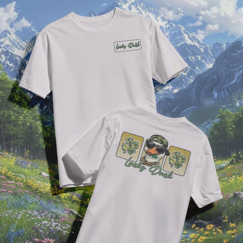 May include: Two white t-shirts. One shirt has a small green text logo that says "Lucky Duck". The other shirt has a graphic of a duck wearing sunglasses and a camo hat, with the text "Lucky Duck".