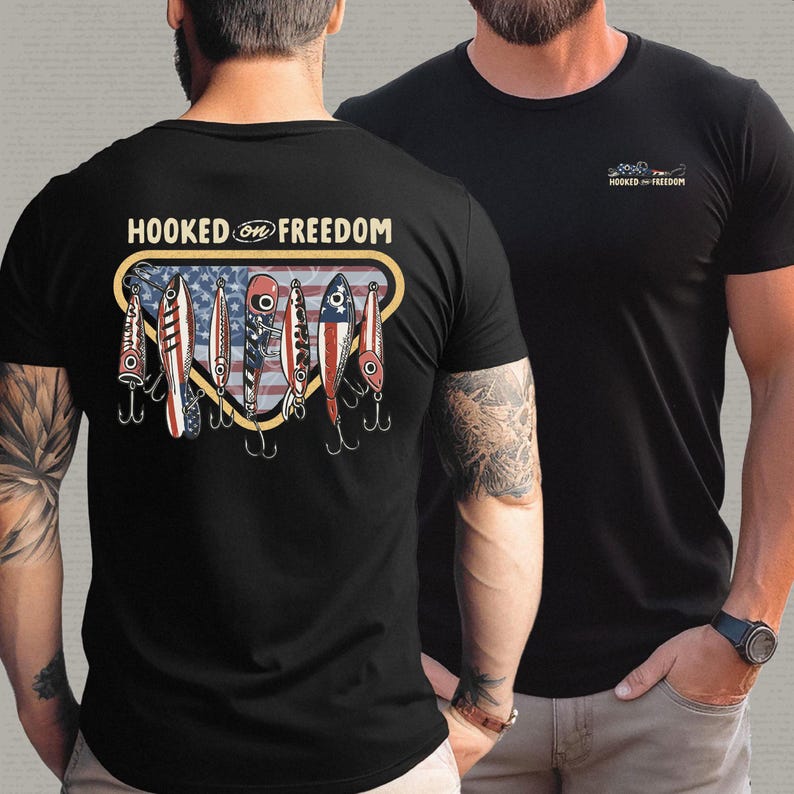 May include: Black t-shirt with a graphic on the back featuring fishing lures with an American flag design and the text "HOOKED ON FREEDOM". A smaller version of the graphic is on the front.