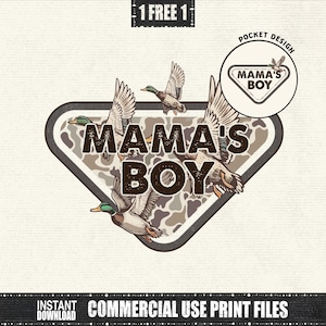 May include: A graphic design featuring the text "MAMA'S BOY" in a brown, bold font, set against a camouflage pattern within a shield shape. Ducks are illustrated in flight around the text. The design includes a smaller pocket design with the same text.