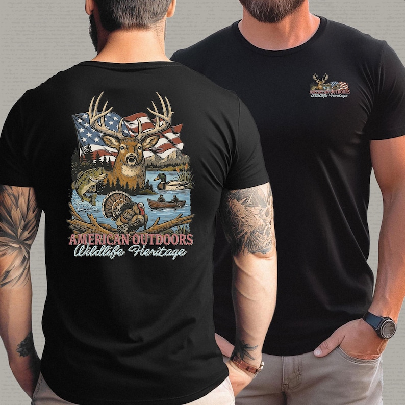 以下が含まれることがあります： 黒いTシャツ。鹿、アメリカ国旗、野生生物のシーンのグラフィックが特徴です。「AMERICAN OUTDOORS WILDLIFE HERITAGE」の文字が下に表示されています。グラフィックの小さなバージョンがシャツの前面にあります。