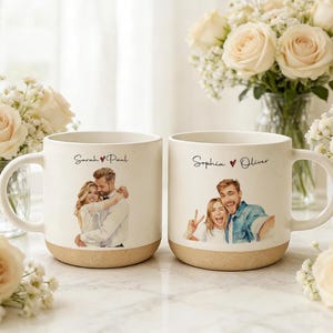 Puede incluir: Dos tazas de cerámica color hueso con textura moteada y base beige. La taza izquierda muestra el texto Sarah ♥ Paul sobre una ilustración de una pareja. La taza derecha muestra el texto Sophia ♥ Oliver sobre una ilustración de una pareja.