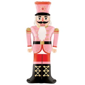 May include: A pink and gold nutcracker balloon with a black hat and boots. The nutcracker has a white beard and mustache and a red and gold uniform.