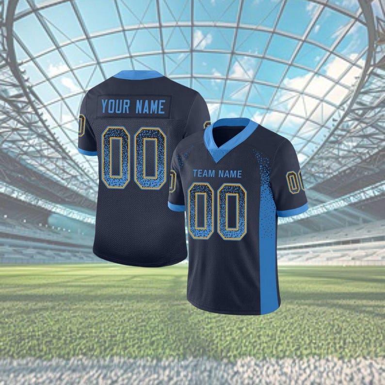 Puede incluir: Dos camisetas deportivas azul marino con detalles en azul claro. Cada camiseta muestra el n&uacute;mero "00" en azul claro con un contorno dorado. Una camiseta tiene "YOUR NAME" y la otra "TEAM NAME" impreso en la espalda.